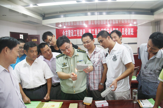 图为枣庄市消防支队防火处参谋王磊在为参加培训人员进行保温材料耐火试验